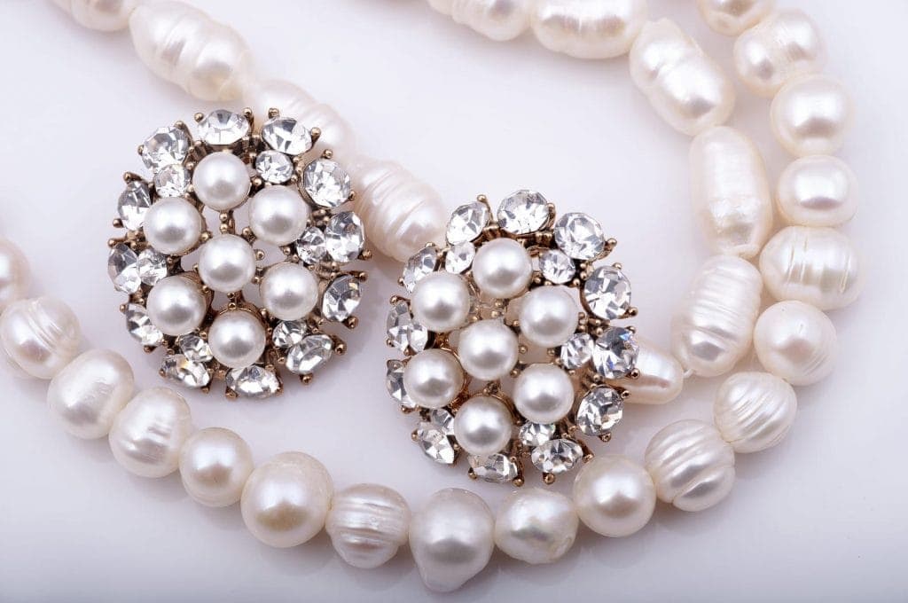 Pearl necklace and pearl earrings on a white background