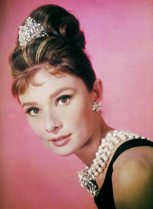 Audrey Hepburn wearing pearl necklace and dark dress