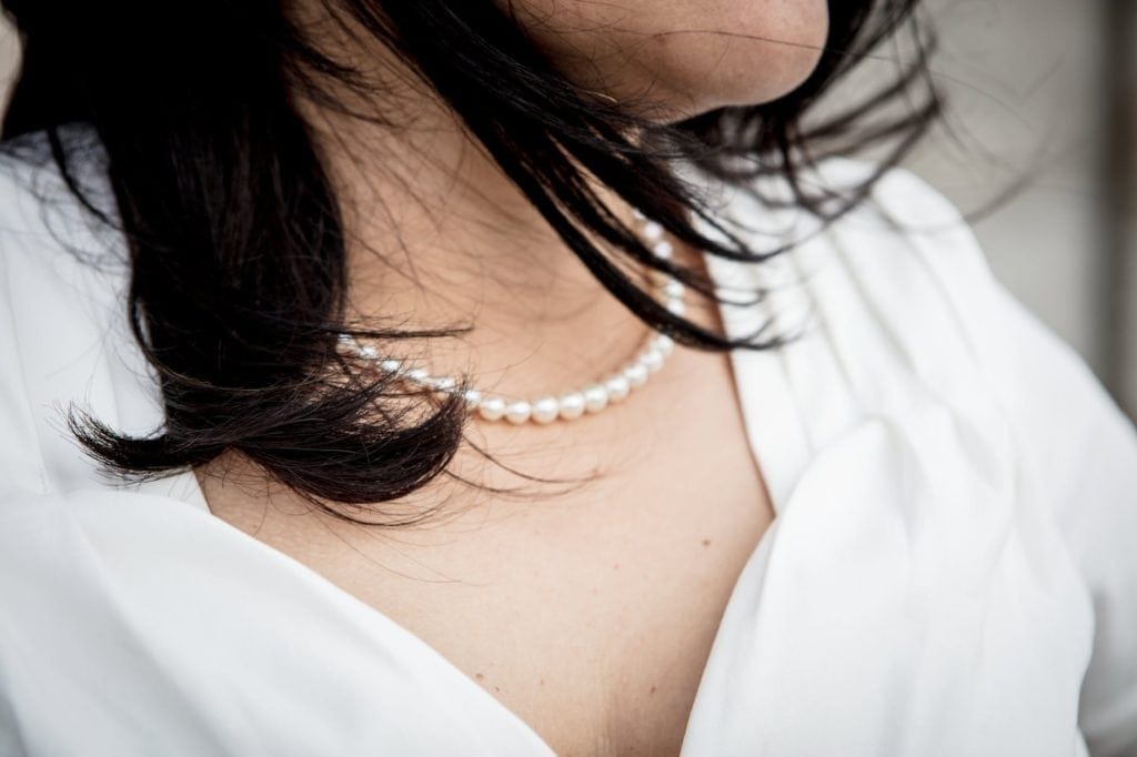 Woman wearing choker length pearl necklace